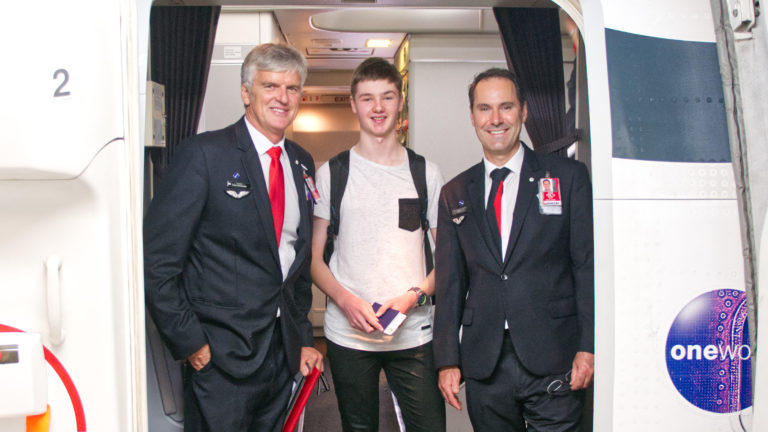 Michael Nixon stands at the centre of two Qantas flight attendants.