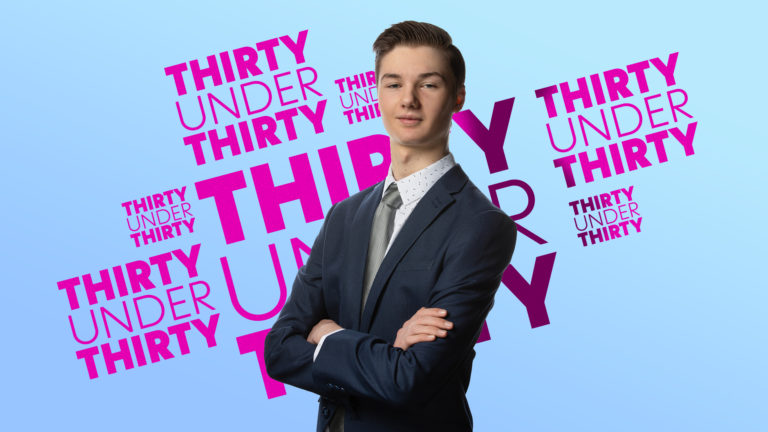 Michael Nixon wears a suit with crossed arms and a distinguished gaze